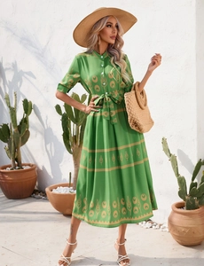 Detail of green summer dress featuring ethnic floral prints and waist tie closure