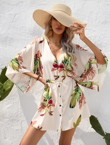 Detail of tropical leaf print dress with deep V-neckline and adjustable waist tie