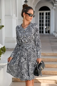 Detail of zebra print dress with V-neck button design and tie-waist in outdoor setting