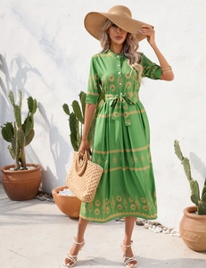 Detail of green summer dress featuring vintage golden prints and white front buttons