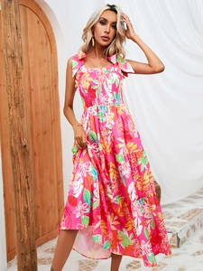 Detail of pink tropical leaf print dress with smocked bodice and tiered floral skirt