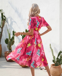 Detailed view of fuchsia floral print pleated midi dress with short sleeves and waist tie