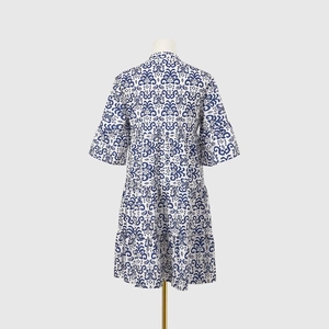 Détail de la robe à volants blanche avec motif floral bleu vintage et col en V