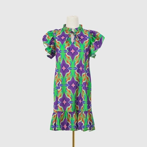 Detail of ruffle stand collar with tie-up neckline and vibrant geometric floral print