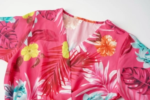 Detail of the V-neckline on the pink tropical floral dress with size S label
