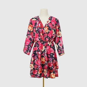 Détail d'une robe fleurie à col en V avec fleurs roses et ourlet à volants superposés