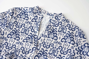 Détail du col en V et de l'imprimé floral bleu porcelaine sur un tissu léger
