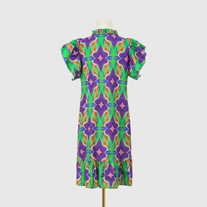 Close-up of bohemian geometric print dress featuring a ruffled collar and tiered hem detail