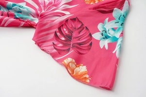 Detail of summer dress featuring vibrant tropical floral print and clean edge stitching