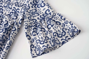 Détail de la robe à imprimé cachemire bleu et blanc avec manches cloches à volants