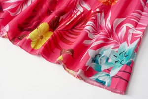 Detailed close-up of rose red floral print pleated dress with fine rolled hem stitching