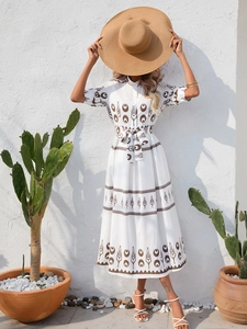 Close-up of ethnic print shirt dress with belted waist and mid-length sleeves