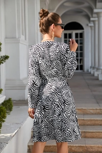 Detail of long-sleeved zebra print maxi dress with high waist cinched design for women