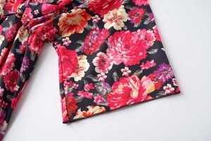 Gros plan de l'imprimé floral vif sur tissu noir montrant les détails de couture