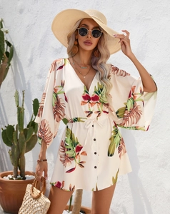 Detail of summer dress featuring tropical leaf print with V-neck and drawstring waist