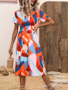 Detailed view of deep V-neck and elastic high waist on colorful geometric print midi dress