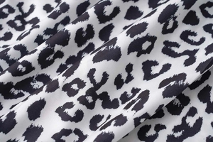 Close-up of lightweight chiffon fabric with chic black and white leopard print details