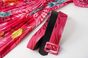 Detailed view of pink floral pleated dress with a matching square buckle belt
