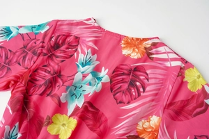 Detail of rose pink tropical floral print with hibiscus and palm leaves on summer dress