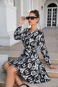 Detail of black and white geometric print shirt dress with tie waist and gold cuff buttons