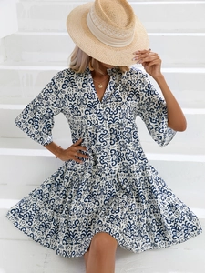 Détail du décolleté en V et ourlet à volants sur robe de vacances imprimé bleu