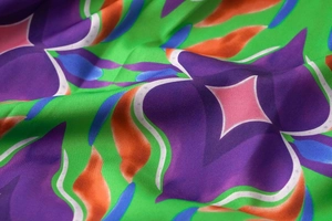 Close-up of silk fabric with floral patterns in purple, green, and orange colors