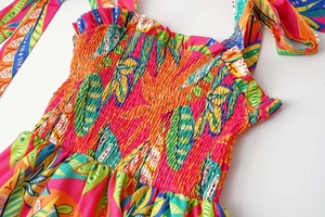Detail of colorful tropical leaf print dress with smocked bodice and self-tie shoulder straps