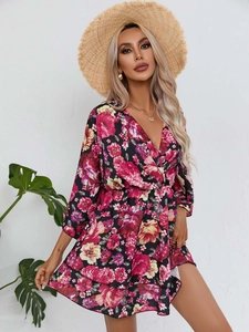 Détail d'une robe d'été à col en V avec fleurs roses et ourlet à volants