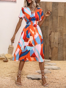 Detail of smocked waist and colorful geometric floral print on summer V-neck dress