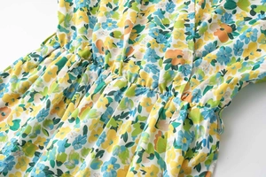 Détail de la taille élastique froncée sur une robe en mousseline au motif floral coloré