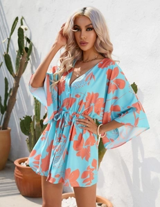 Close-up of summer dress featuring leaf print, deep V-neck, and drawstring waist detail