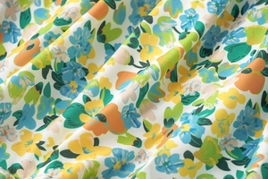 Vue détaillée du motif floral multicolore sur tissu mousseline blanc léger