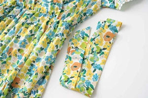 Détail de la robe à fleurs avec bordure en dentelle blanche sur le bord de la manche