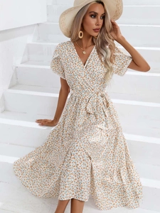 Gros plan d'une robe fleurie à col en V avec lien à la taille et manches à volants