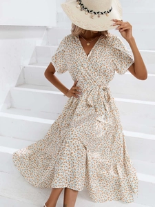 Détail de robe portefeuille fleurie avec col en V, manches volantées et nœud à la taille