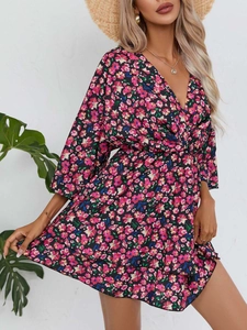 Détail de robe courte fleurie avec col en V, volants et taille cintrée