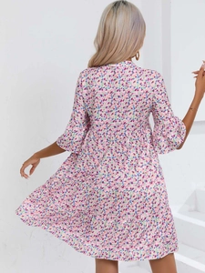 Détail d'une robe fleurie montrant des manches à volants et un tissu en mousseline