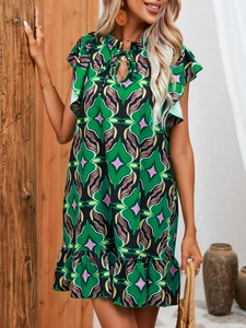 Detail of bohemian green print dress featuring ruffled sleeves and a V-neck tie closure