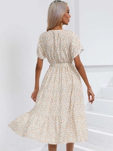 Vue détaillée du dos d'une robe mi-longue fleurie blanche avec ourlet à volants
