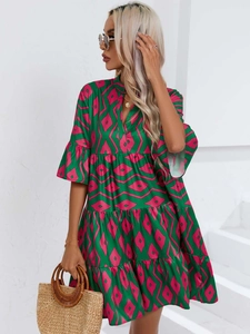 Détail de mini robe à volants col en V avec motifs géométriques rose et vert et manches volantées
