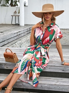 Detail of short sleeve tropical print shirt dress with belt and front buttons
