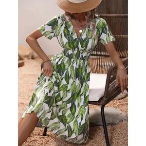 Detail of tropical green leaf print on white V-neck dress with elastic waist design