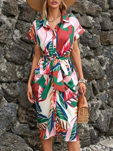 Detail of tropical leaf print shirt dress with button-front and waist tie design