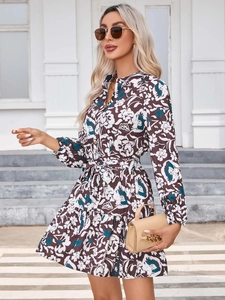 Detailed view of floral long sleeve dress with waist tie and lantern sleeves in dark brown