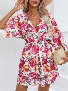 Détail d'une robe fleurie à col en V avec ourlet croisé et motif imprimé estival
