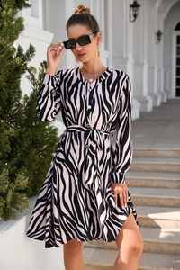 Detailed close-up of a zebra print dress featuring long sleeves and a button-down V-neck