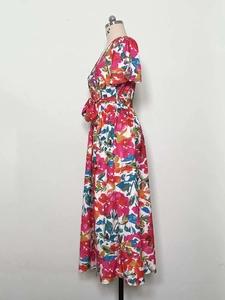Detail of vibrant floral print dress with V-neckline and ruffle sleeves on mannequin
