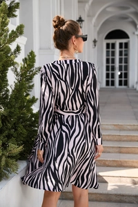 Detail of the zebra print maxi dress featuring long sleeves and a tapered waist design