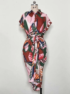 Close-up of tropical palm leaf print and button-down detail on a summer shirt dress