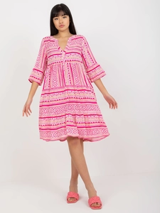 Détail de l'imprimé géométrique rose et blanc sur une robe bohème ample à volants